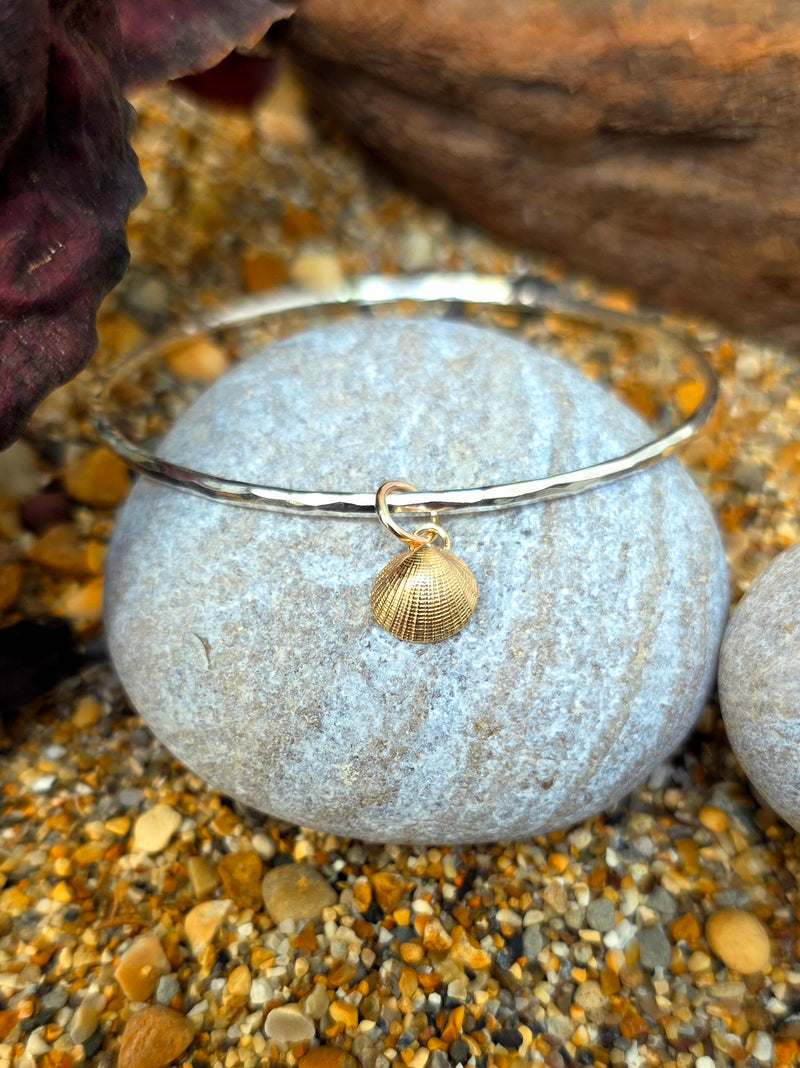 Silver simplicity bangle with a 9ct yellow gold scallop shell charm, 2026