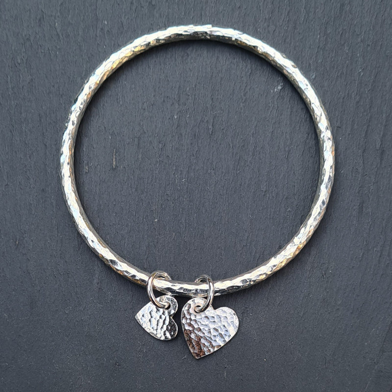 Beaten halo bangle with two heart charms, 2022